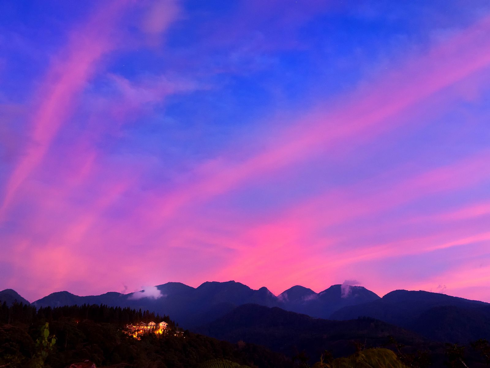 Mountain With Clouds In Background Of Blue And Purple Sky