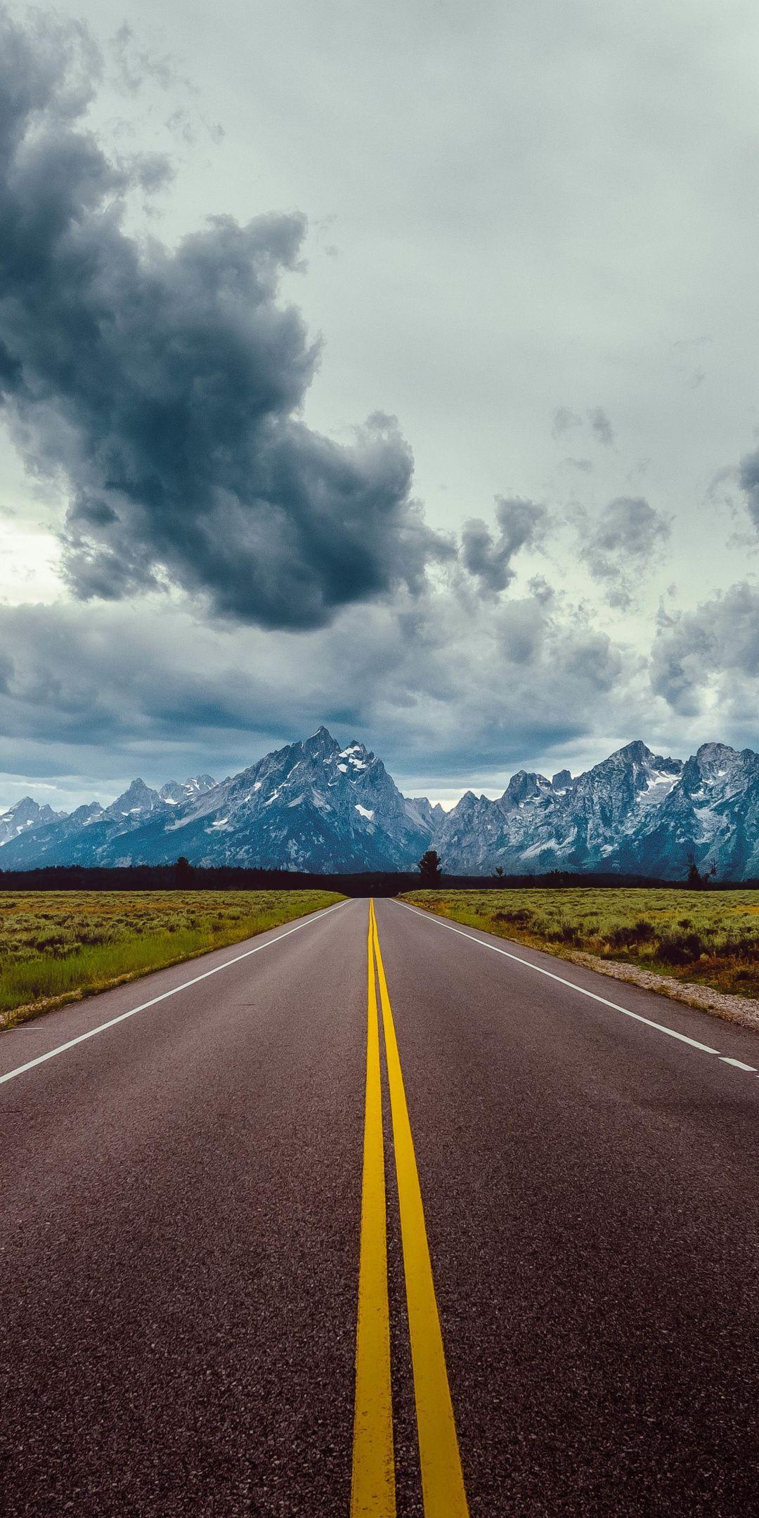 Road With Background Of Mountains And Clouds