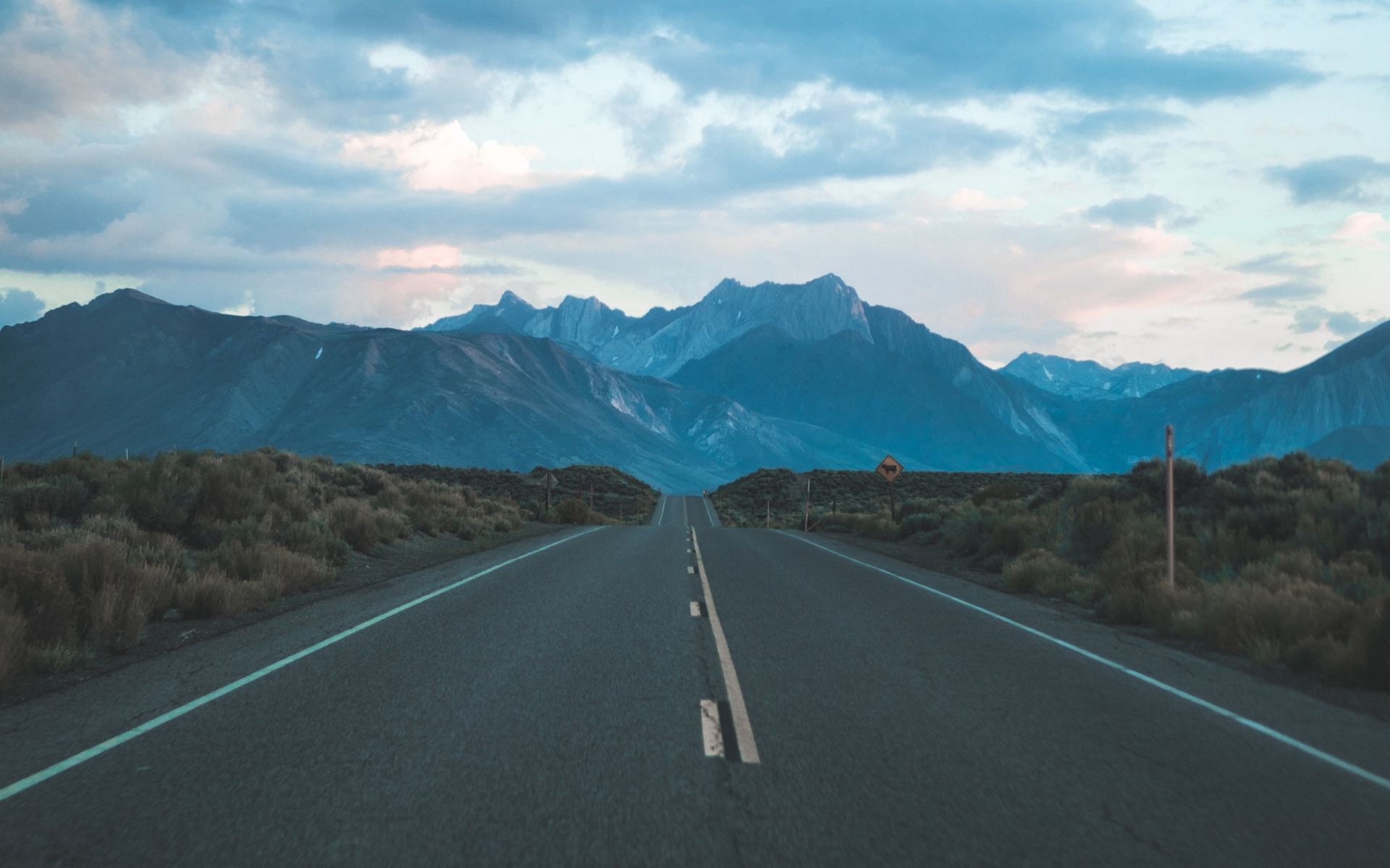 Road With Background Of Mountains And Clouds