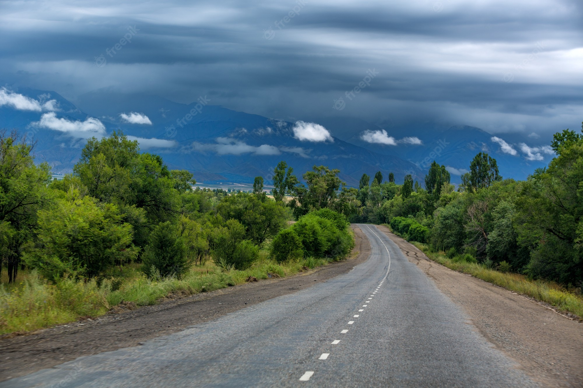 Road With Background Of Mountains And Clouds